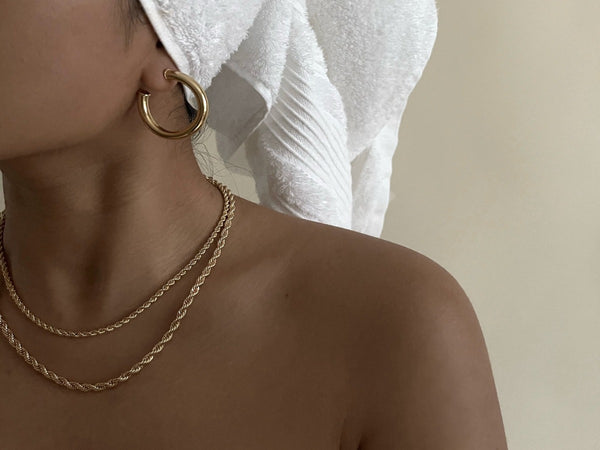 woman wearing chunky gold hoop earrings and thick gold necklace rope necklace
